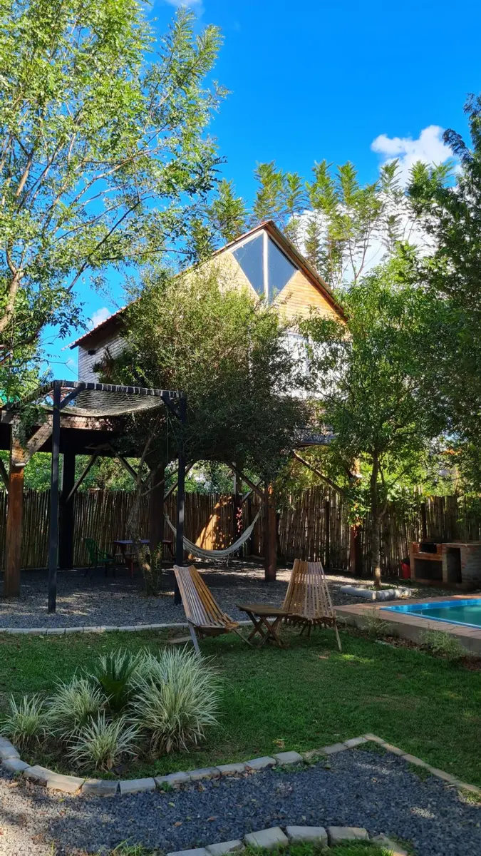 La Casa del Árbol vista desde el patio, con la pileta y las hamacas